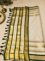 A timeless cream and gold tissue  saree with rich dark green detailing